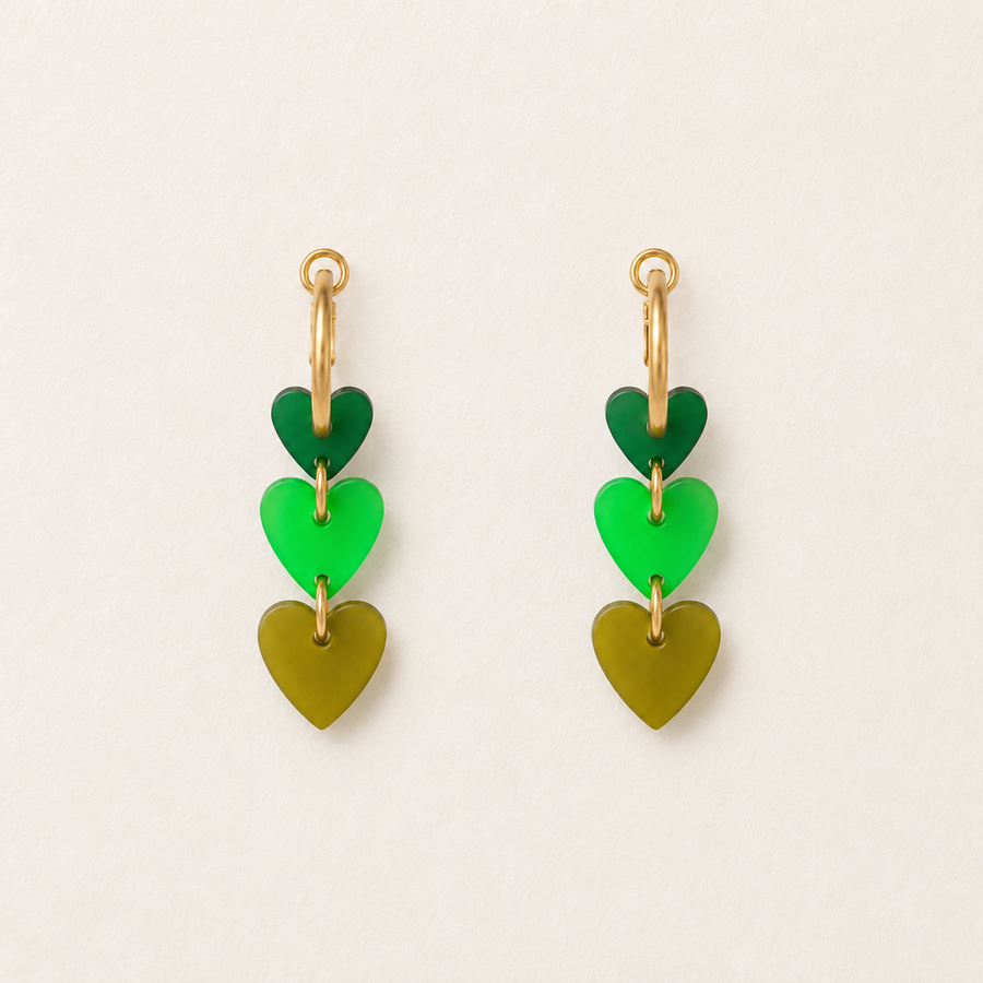 Pair of green heart-shaped earrings on a light beige background