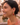 Woman wearing green heart-shaped earrings with a blurred background