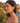 Woman wearing colorful heart-shaped earrings with a scenic background