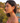 Woman wearing red heart-shaped earrings with a scenic background