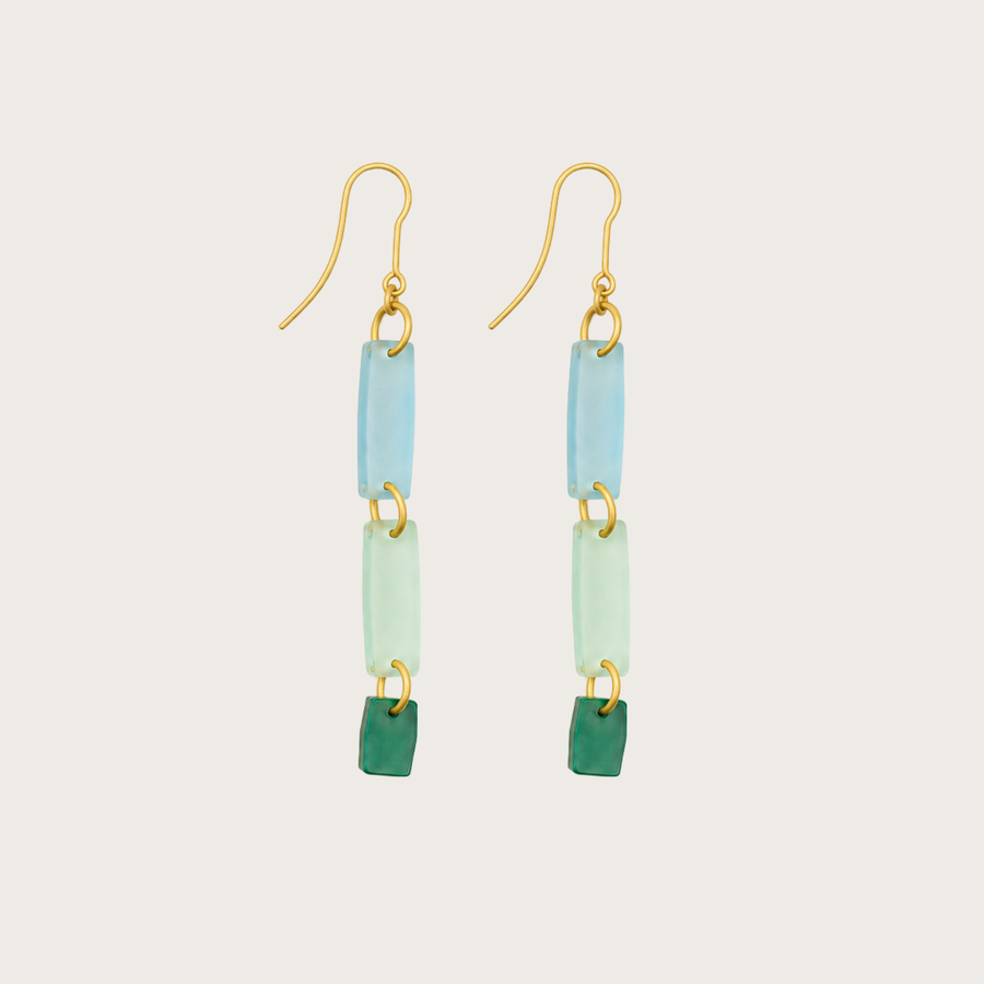Pair of earrings with gold hooks, blue and green rectangular beads on a light gray background