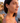 Woman wearing heart-shaped earrings with a scenic background
