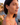 Woman wearing heart-shaped earrings with a scenic background