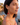 Woman wearing red heart-shaped earrings with a scenic background