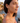 Woman wearing a heart-shaped earring with a scenic background