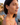 Woman wearing a heart-shaped earring with a scenic background