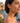 Woman wearing floral earrings with a scenic background