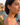 Woman wearing floral earrings with a scenic background