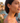 Woman wearing orange earrings with a scenic background