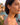 Woman wearing orange earrings with a scenic background