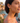 Woman wearing yellow flower earrings with a scenic background