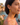 Woman wearing yellow flower earrings with a scenic background