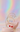 Surreal pastel campaign image for Materia Rica Dalí Dream Icons featuring Ruby Lips, Floating Pearls and Melting Clocks earrings on a gold sculptural display.