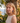 Woman with blonde hair standing outdoors with a scenic background