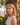 Woman with blonde hair standing outdoors with a scenic background