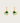 Heart-shaped green earrings with gold hooks on a light beige background