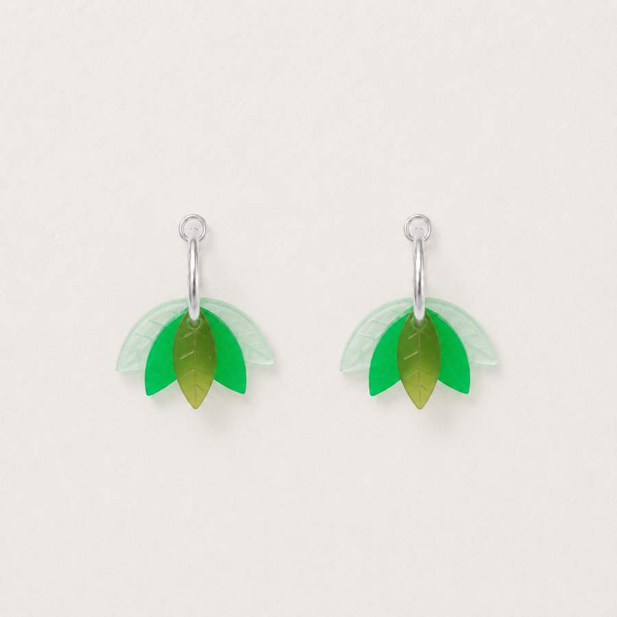 Pair of green leaf-shaped earrings on a light gray background