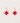 Pair of earrings with pink and red leaf-like charms on gold hooks against a light gray background