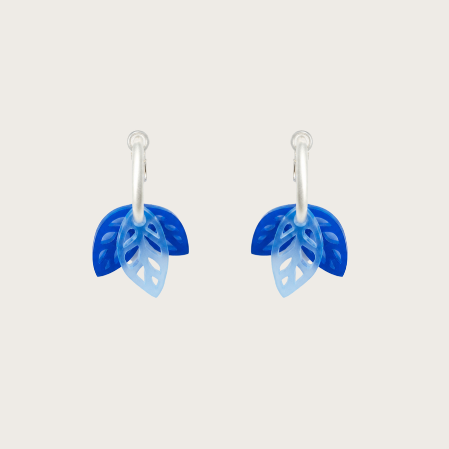 Blue leaf-shaped earrings on a light gray background